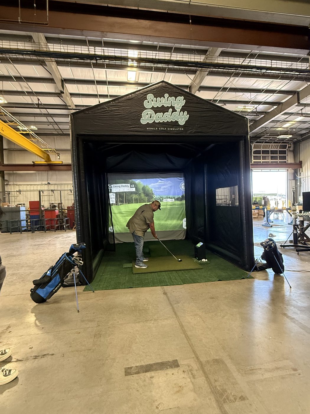Guest playing the Swing Daddy mobile golf simulator at an Oklahoma event